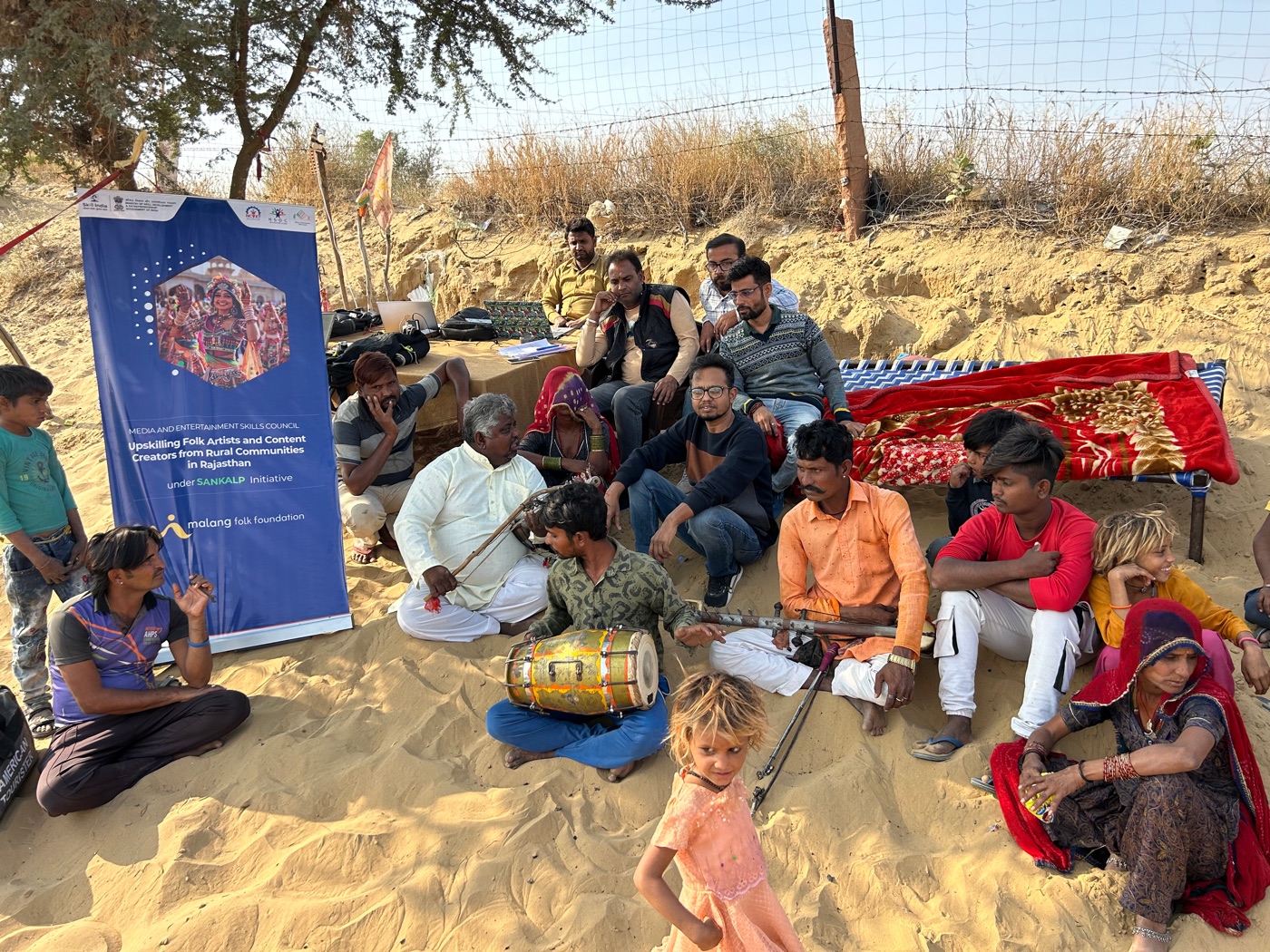 Folk musicians from rural Rajasthan at a Malang Folk Foundation upskilling session, seated with a dholak and bowed instruments.