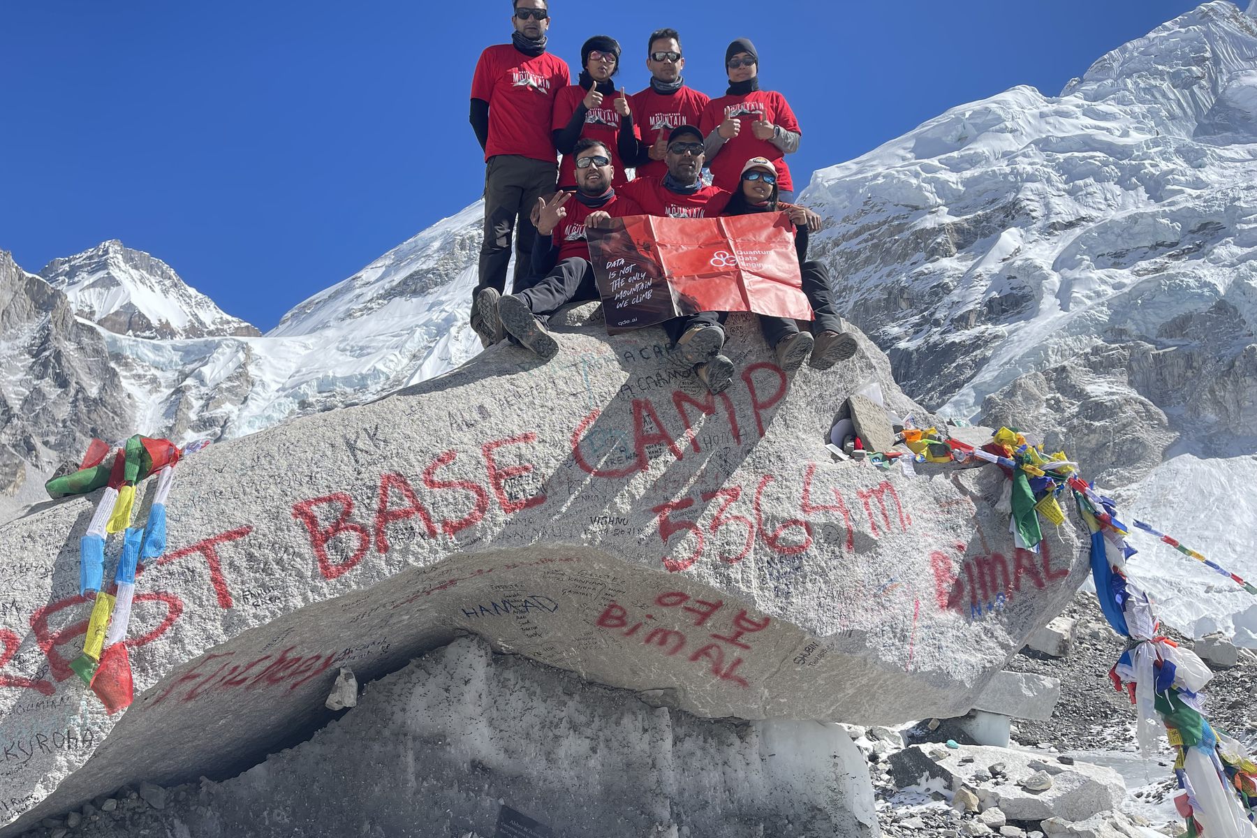 The QDE team at the Everest Base Camp marker rock, 5364 metres