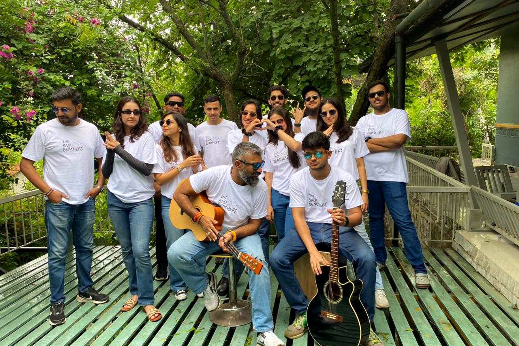 The band on an outdoor deck with acoustic guitars