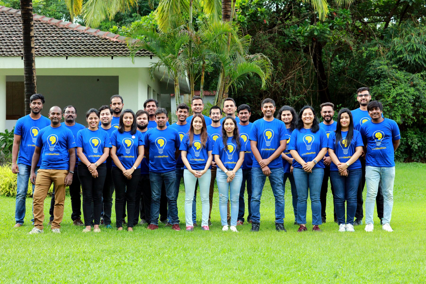 The Ideathon cohort in lightbulb tees together on a lawn
