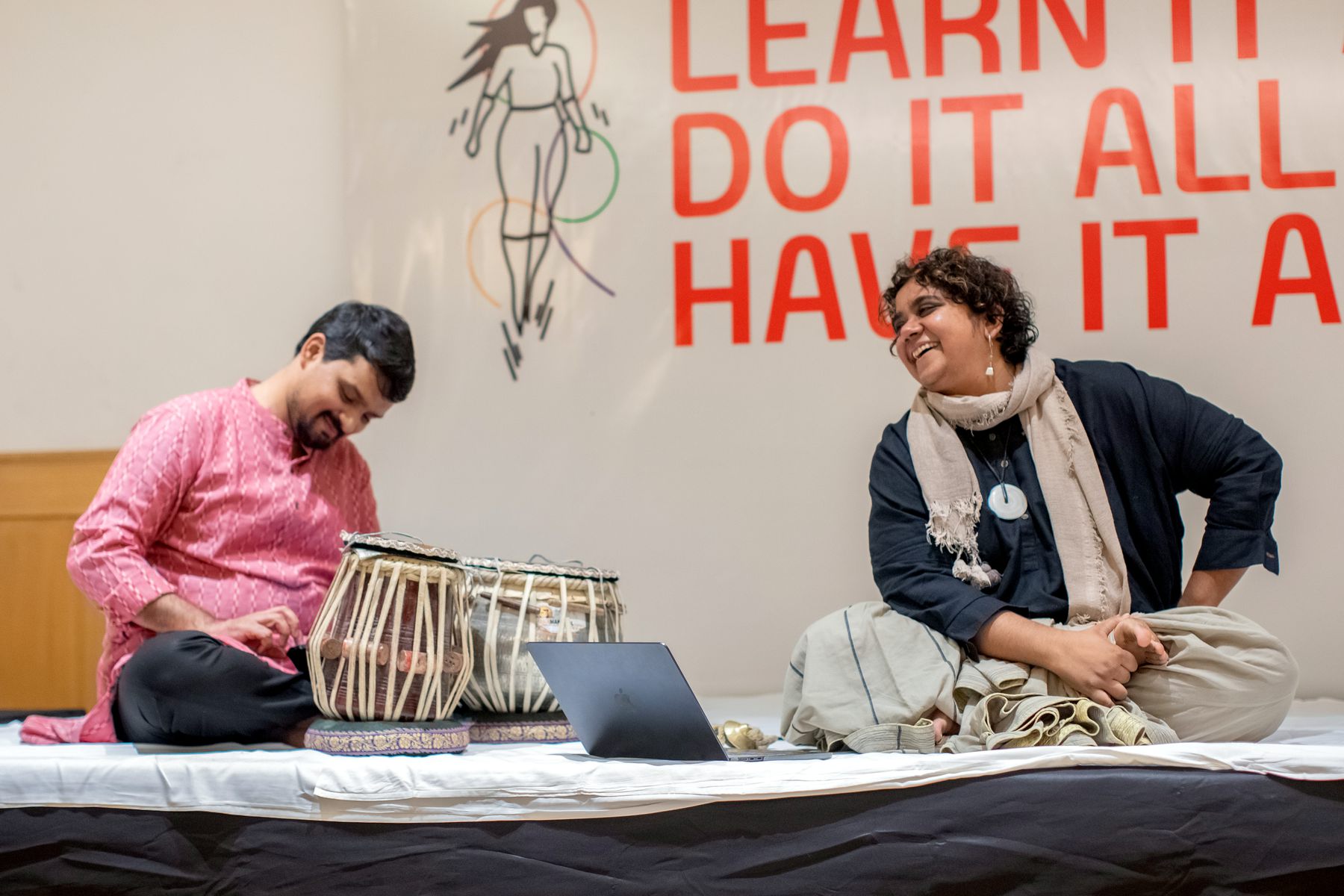 A tabla player and a participant sharing a laugh during a WEEW session